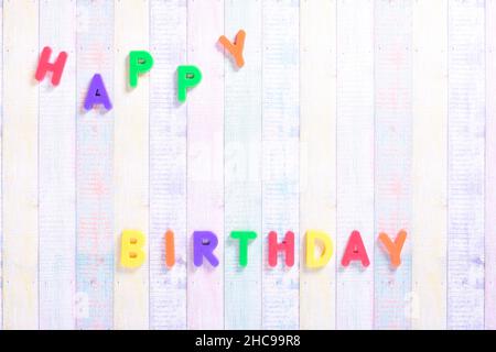 Photograph of some magnet letters with the English text of Happy Birthday on a colored cardboard background.The photograph is shot in horizontal forma Stock Photo