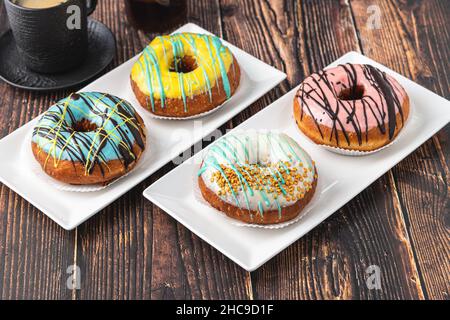 Delicious donuts decorated with different decorations on wooden table Stock Photo