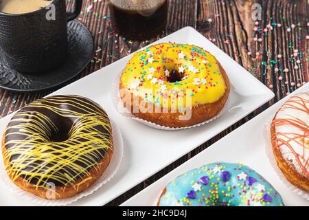 Delicious donuts decorated with different decorations on wooden table Stock Photo