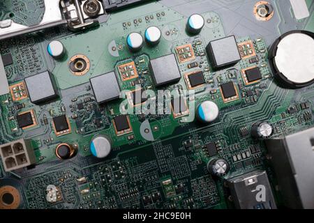 Close-up of a computer board with various solder joints capacitors transistors and chips Stock Photo