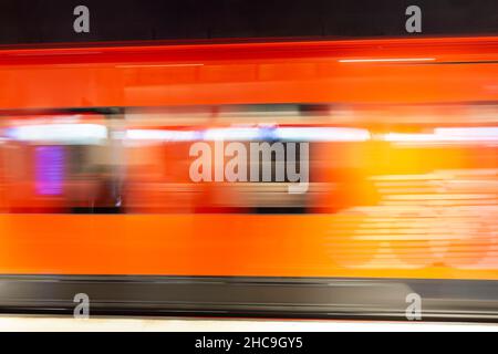 Abstract photo of Helsinki's orange subway train in motion at an underground station in Finland. Heavy motion blur. Stock Photo