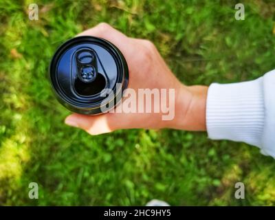 Close-Up Of Hand Holding Black Painted Can Stock Photo