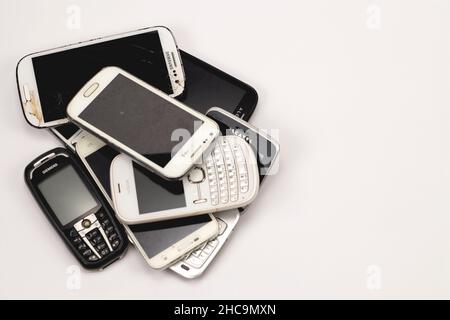 A pile of old mobile phones isolated on a white background. Place for text. Stock Photo