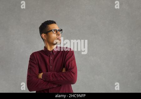 Offended african american man with funny frowning expression on gray background. Stock Photo