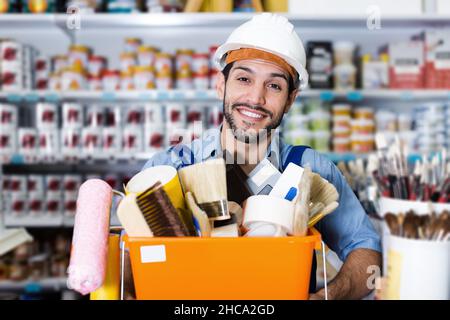 Smiling workman with tools in hands with purchases Stock Photo