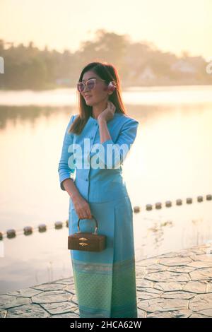 beautiful asian woman wearing thai tradition clothes standing outdoor against morning light Stock Photo