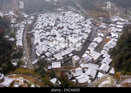 CONGJIANG, CHINA - DECEMBER 26, 2021 - An aerial photo taken on Dec. 26, 2021 shows snow scenery in a traditional Chinese village in Congjiang County, Stock Photo