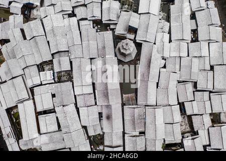 CONGJIANG, CHINA - DECEMBER 26, 2021 - An aerial photo taken on Dec. 26, 2021 shows snow scenery in a traditional Chinese village in Congjiang County, Stock Photo