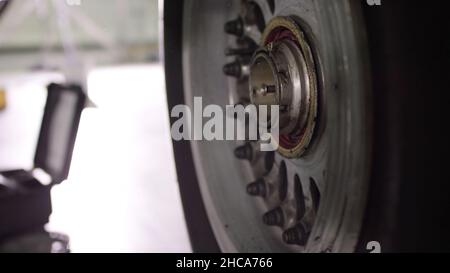Airport worker checking chassis. Engine and chassis of the passenger airplane under heavy maintenance. Engineer checks the aircraft chassis and engine Stock Photo