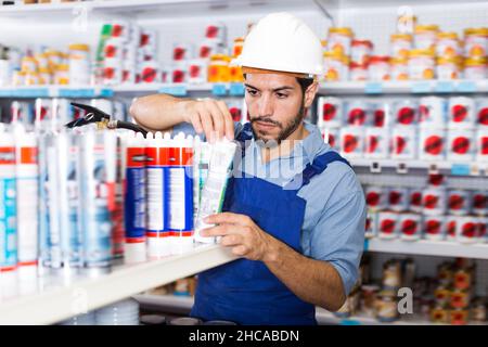 Concentrated young handyman choosing materials Stock Photo