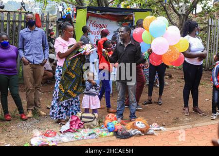 Nairobi, Kenya. 25th Dec, 2021. A vendor selling balloons to families on Christmas Day. For many years, Kenyans living in Nairobi and its environs have spent Christmas Day at the Uhuru and Central parks. However, that is not the case this year, as the two parks remain closed for renovations. This did not stop them from enjoying the day in small spaces that were available. Credit: SOPA Images Limited/Alamy Live News Stock Photo