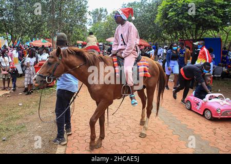 Nairobi, Kenya. 25th Dec, 2021. Children enjoy a horse and car ride on Christmas Day. For many years, Kenyans living in Nairobi and its environs have spent Christmas Day at the Uhuru and Central parks. However, that is not the case this year, as the two parks remain closed for renovations. This did not stop them from enjoying the day in small spaces that were available. Credit: SOPA Images Limited/Alamy Live News Stock Photo