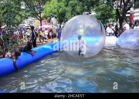 Nairobi, Kenya. 25th Dec, 2021. Kenyan children enjoy water bubbles at a carnival on Christmas Day. For many years, Kenyans living in Nairobi and its environs have spent Christmas Day at the Uhuru and Central parks. However, that is not the case this year, as the two parks remain closed for renovations. This did not stop them from enjoying the day in small spaces that were available. Credit: SOPA Images Limited/Alamy Live News Stock Photo