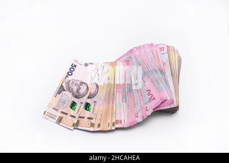 a stack of Ukrainian hryvnia banknotes 200 and 500 on a white background. wad of money. UAH Stock Photo