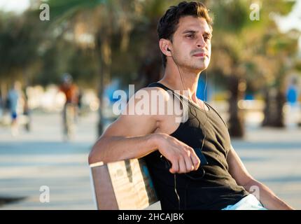 Sporty man resting on bench after workout Stock Photo