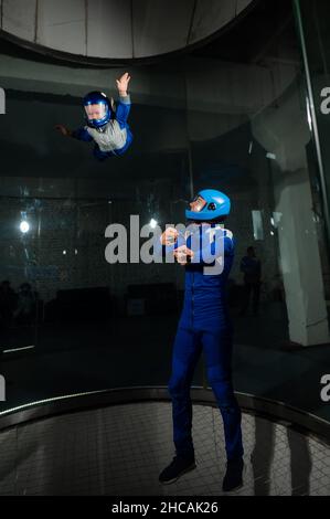 A man teaches a boy to fly in a wind tunnel. Stock Photo