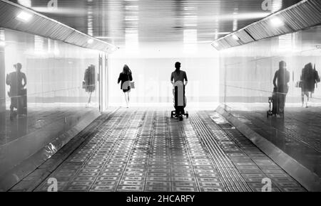 Silhouette of people, girl and woman walking through the passage toward the light outside. concept: seeing light, book or album cover Stock Photo