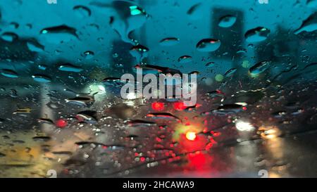 Raindrops at the windshield with red dark background Stock Photo