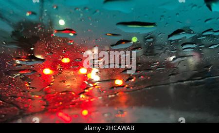 Raindrops at the windshield with red dark background Stock Photo