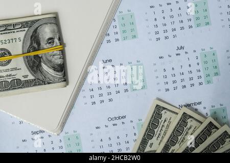 Office workplace desk with dollars and calendar. Counting money for salary. Investment savings. Finances, economy and home concept. Business budget of Stock Photo