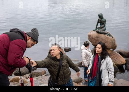 Tourists with camera by Little Mermaid sculpture in Copenhagen, Denmark Stock Photo