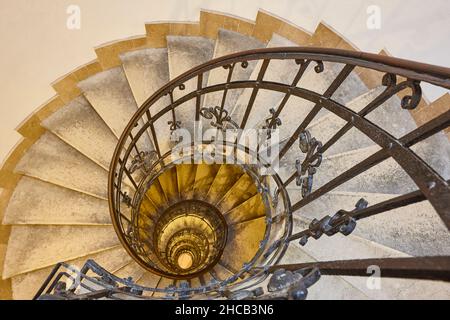 Spiral staircase made with stone and iron. Classic building interior Stock Photo