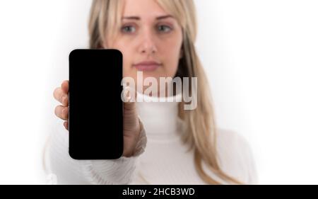 Smartphone being held by an out of focus woman Stock Photo