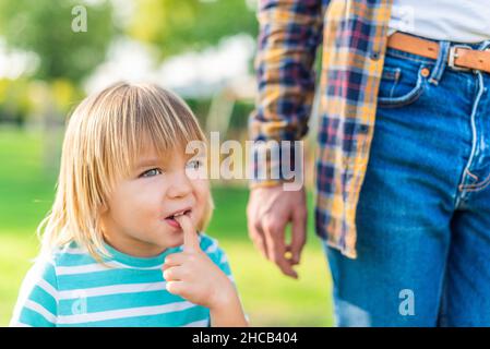 A hesitant little boy in the park with his father Stock Photo