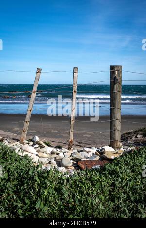 Post and wire fence beside beach at Glenburn, Wairarapa, North Island, New Zealand Stock Photo