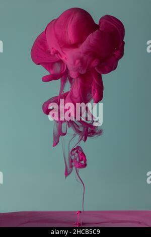 Explosion of colored fluid, ink, dye and neoned liquid on blue-gray studio background with copyspace Stock Photo