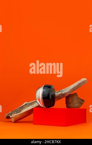 Cosmetic face cream tonal foundation glass jar mockup natural wood podium orange background. Balancing makeup product packaging Smooth BB liquid facia Stock Photo
