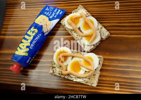 Swedish Sandwich (Smörgåss) with egg slices and Kalles Kaviar on the crisp bread (knäckebröd). On the burned wood background. Stock Photo