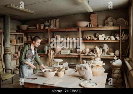 Young woman creating ceramic sculptures with clay at the table in workshop Stock Photo