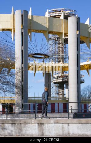 With the New York State Pavilion in the background, a skateboarder rides bye at Maloof Skate Park in Flushing Meadows Corona Park in Queens. Stock Photo
