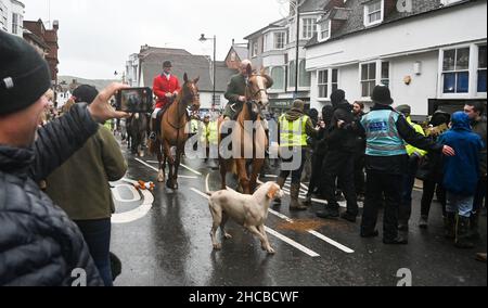 Lewes UK 27th December 2021 - Pro-hunt supporters on the left and hunt saboteurs on the right of the road as the Southdown and Eridge Hunt parade through Lewes town centre on the Boxing Day bank holiday in the UK : Credit Simon Dack / Alamy Live News Stock Photo