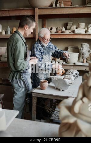 People working making sculptures from clay in team during their work in studio Stock Photo