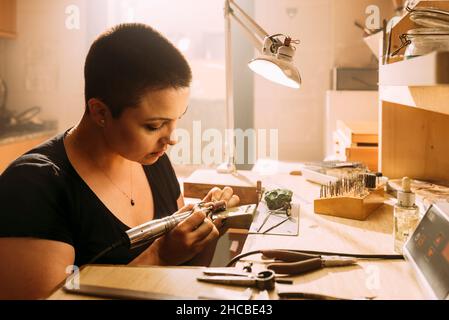 Female expert checking size of silver ring in workshop Stock Photo