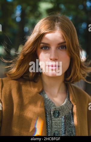 Serious young woman in autumn park Stock Photo