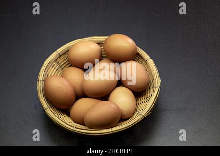 Fresh brown chicken eggs in wicker basket Stock Photo