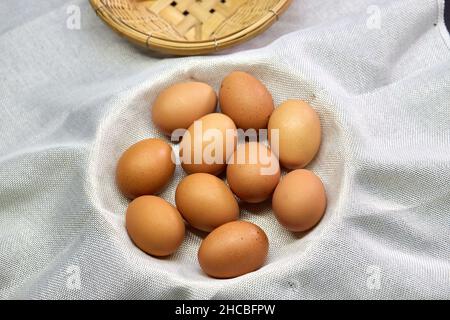 Fresh brown chicken eggs in wicker basket Stock Photo