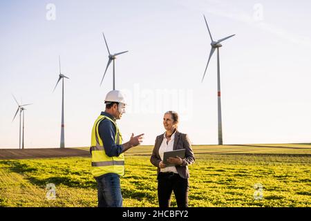 Engineer discussing with colleague on sunny day Stock Photo