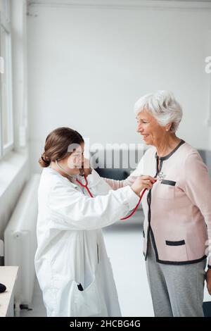 Woman using virtual reality headset in front of white wall Stock Photo