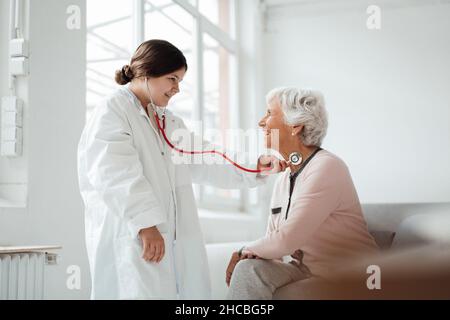 Woman showing mobile phone with girl at home Stock Photo