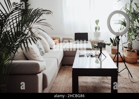 Beauty products with mobile phone by ring light on table in home studio Stock Photo