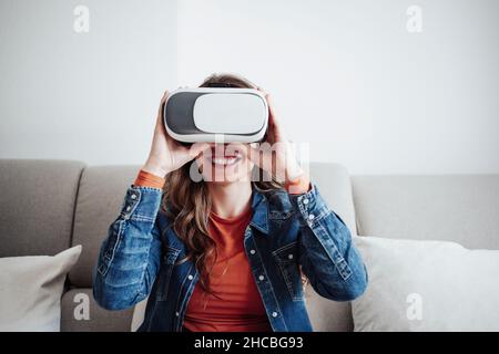 Smiling woman using virtual reality simulator at home Stock Photo