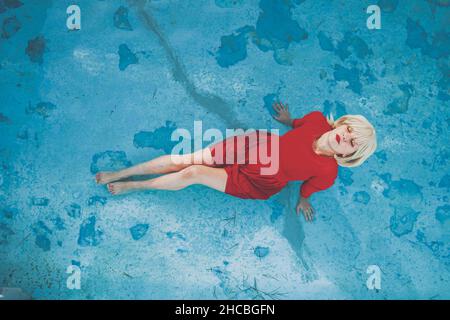 Woman with eyes closed relaxing in swimming pool Stock Photo