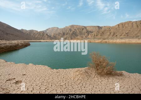 View of the Wadi Beeh Dam on a hot summer day in Ras Al Khaimah, United Arab Emirates. Oasis in the desert concept. Stock Photo