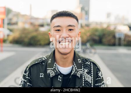 Young man in casual clothing smiling in city Stock Photo