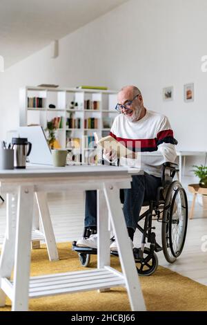 Senior disabled man reading diary at home office Stock Photo