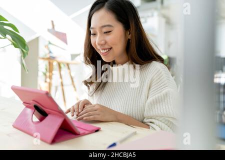 Woman with virtual reality headset playing video game at home Stock Photo
